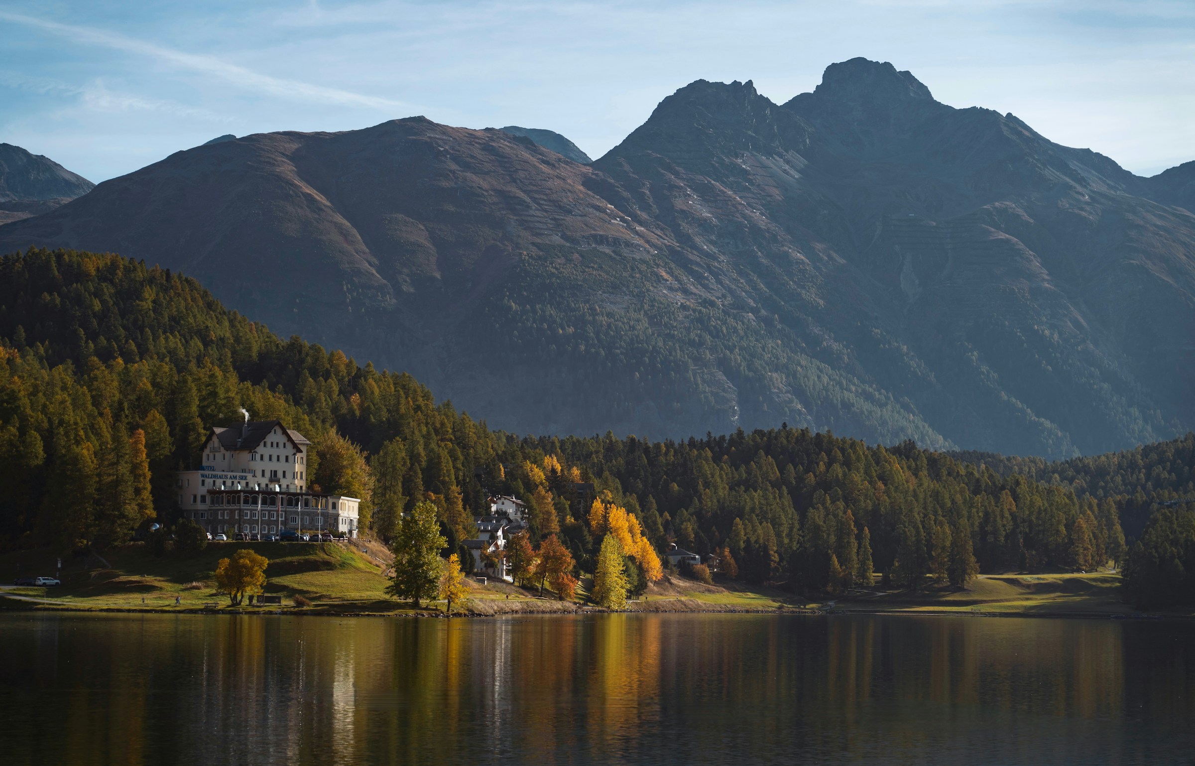Lake St. Moritz in autumn, with golden larches on the wooded south shore; archive photograph by Theodor Esenwein, not current conditions