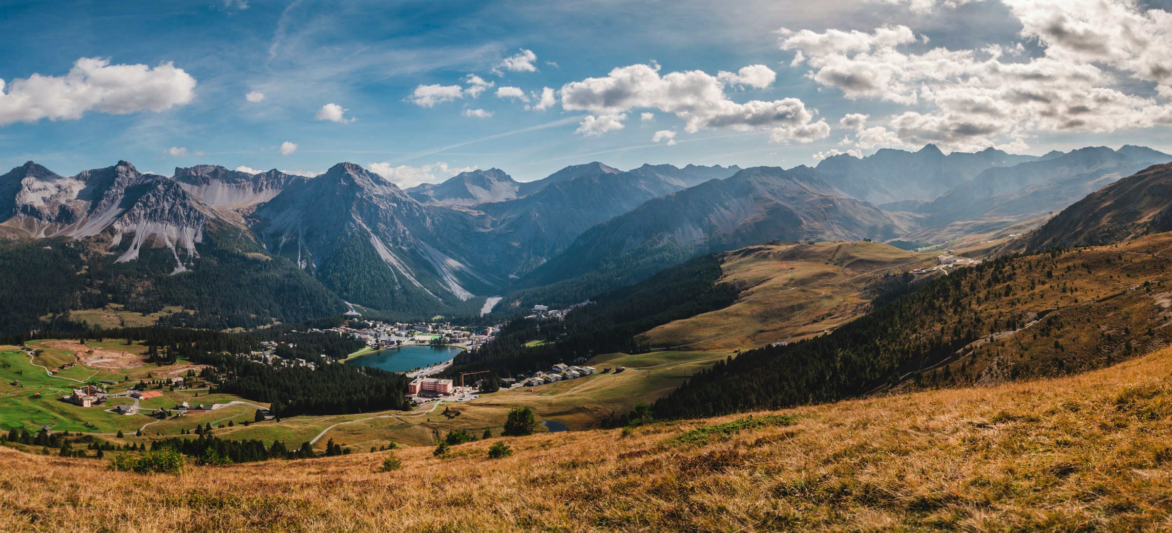 Mountain ridges and a high alpine valley beneath broken cloud in Grisons