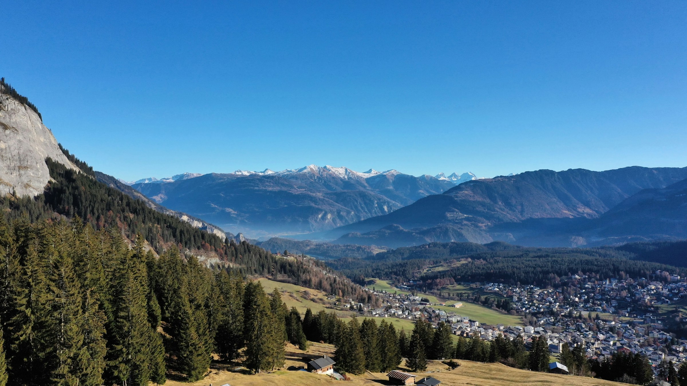 Flims beneath the Flimserstein, with forest and mountain slopes; archival photograph by Janick Wartmann